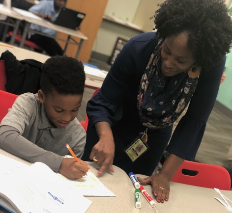A photo of Ms. Hill working with a PLA scholar 
