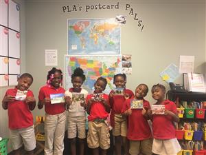 Scholars smiling and holding their postcards 